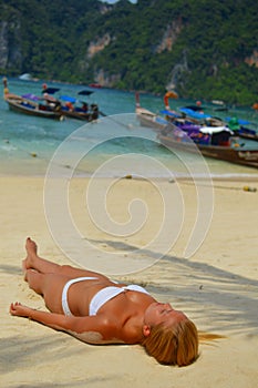 Blond girl suntanning on the beach