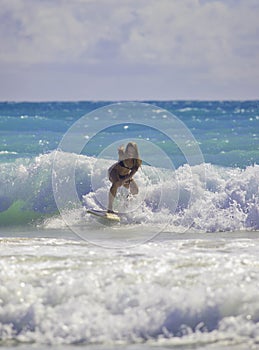 Blond girl surfing the waves