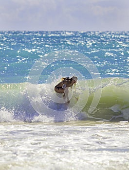 Blond girl surfing the waves