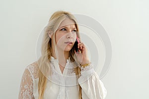 Blond girl is talking on the phone and she looks unhappy