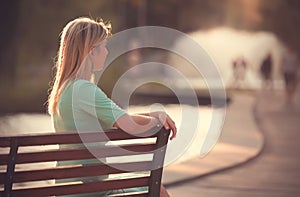 Blond hair woman pondering in the park