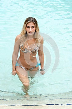 Blond haired model wearing a swimsuit at a pool