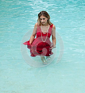 Blond haired model wearing a swimsuit at a pool