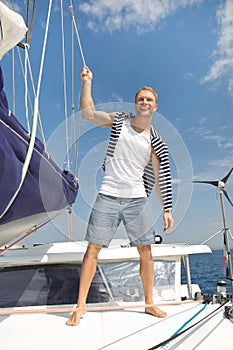 Blond handsome young man on sailing boat.