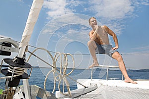 Blond handsome young man on sailing boat.