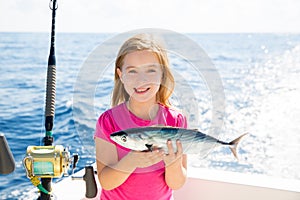Blond kid girl fishing tuna bonito sarda fish happy catch photo