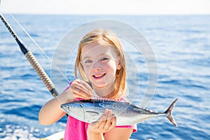 Blond kid girl fishing tuna little tunny happy with catch