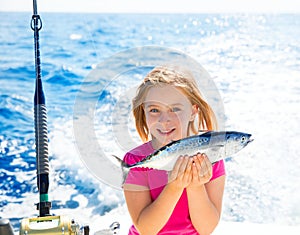 Blond kid girl fishing tuna little tunny happy with catch