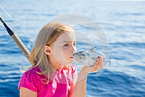 Blond kid girl fishing tuna little tunny kissing for release
