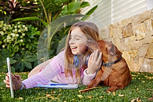 Blond kid girl selfie photo tablet pc and dog