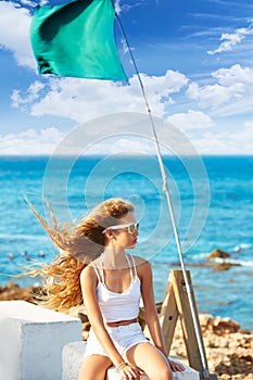 Blond kid teen girl on the beach long curly wind hair