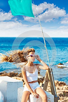 Blond kid teen girl on the beach long curly wind hair