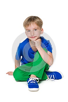 Blond little boy in the green pants sits