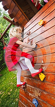 Blond little girl on a climbing wall