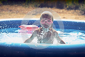 Blond little girl playing in the pool