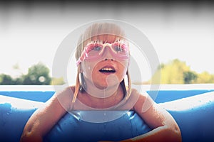 Blond little girl playing in the pool