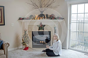Blond Mature Woman by Fireplace with Christmas Decor