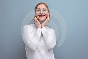 blond pensive middle-aged woman in a white sweater