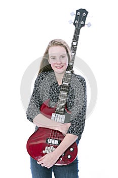 Blond teen girl and bass guitar against white background in studio