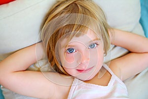 Blond relaxed girl on pillow blue eyes smiling