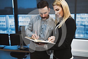 Secretary helping boss in office at workplace