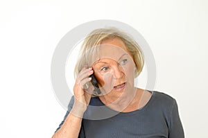 Blond senior woman having a conversation on mobile