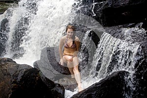 Blond sits on rock