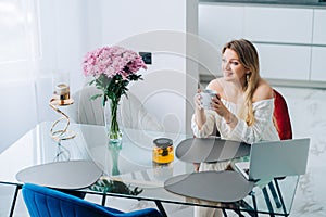 Blond smiling woman kitchen citrus herbal tea pot. Remote working video call