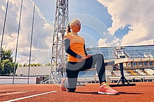 Blond sporty female runner to quick start position.
