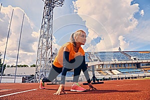 Blond sporty female runner to quick start position.