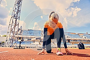 Blond sporty female runner to quick start position.