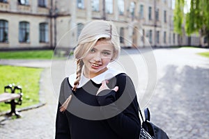 Blond student girl in schoolyard