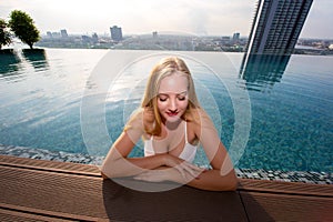 Blond swim wear model in a white sequined bikini with string ties