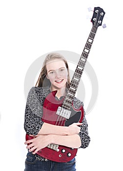Blond teen girl and bass guitar against white background in studio