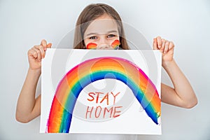 Blond teen girl drew rainbow and poster stay home. photo