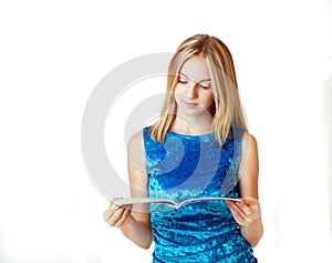 Blond teenage girl reading fashion magazine