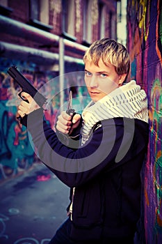 Blond teenager holding a pistol and knife