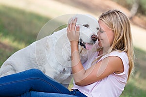 Blond teenager with old senior labrador dog in the park