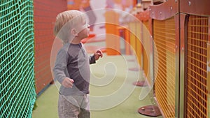 Blond toddler with blue eyes looks at camera with scare and turns his head