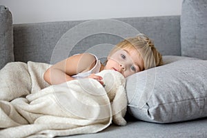 Blond toddler child, wiping his nose in a tissue, sneezing and coughing