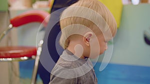 Blond toddler looks at camera and drinks water