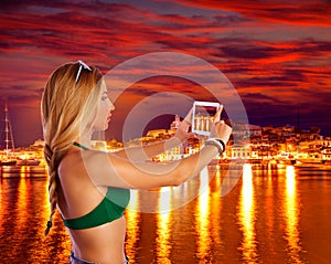 Blond tourist girl taking photos of Ibiza skyline