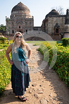 Blond tourist poses at the Tomb of Sheesh Gumbad tomb in Lodi Gardens in New Delhi, India