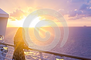 Blond watching sunset from cruise ship in caribbean sea near Phi