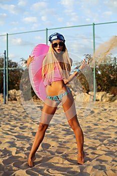blond woman in bikini posing on the beach