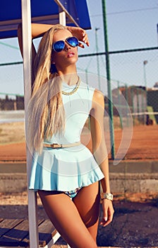 blond woman in blue dress on the beach