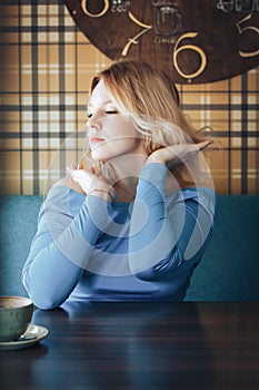 Blond woman in blue dress in cafe