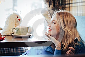 Blond woman in blue dress in cafe