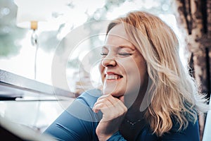 Blond woman in blue dress in cafe