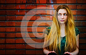 Blond woman and brick wall